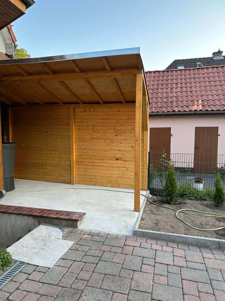 Überdachte Holzkonstruktion mit seitlicher Verkleidung im Außenbereich