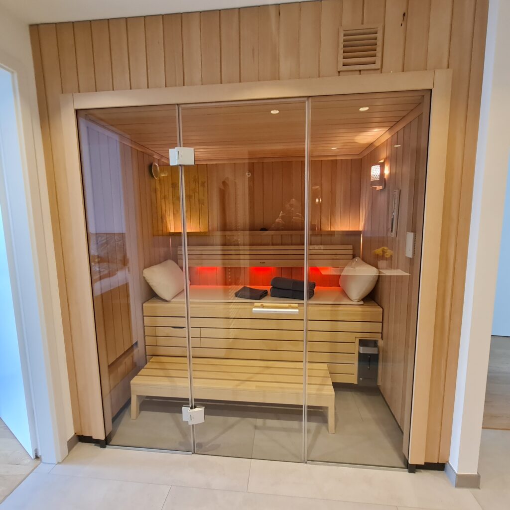 Saunakabine mit Holzverkleidung und Glasfront im Innenraum