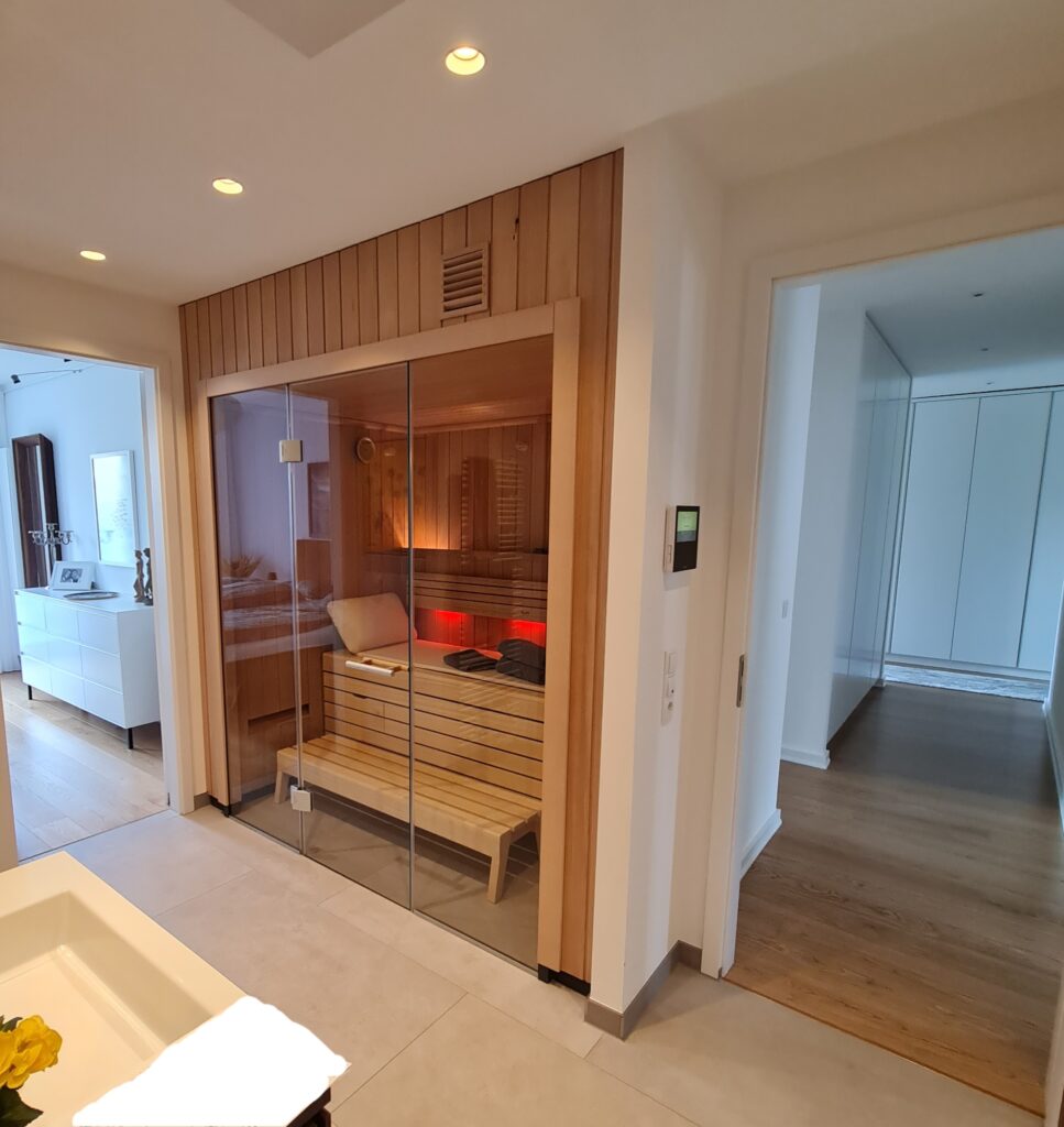 Saunakabine mit Holzverkleidung und Glasfront im Innenraum