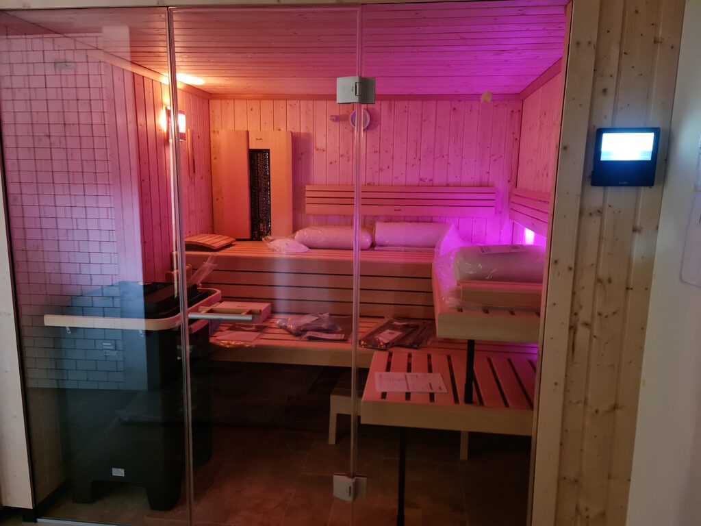 Beleuchtete Saunakabine mit Glasfront im Innenraum