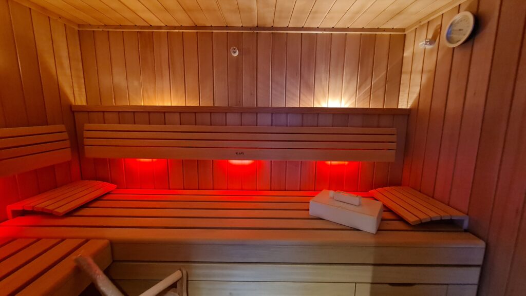 Holzbänke mit roter Beleuchtung im Saunainnenraum