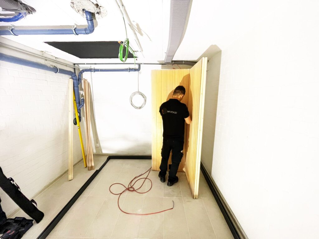 Monteur bei der Arbeit an einem hölzernen Saunabauteil