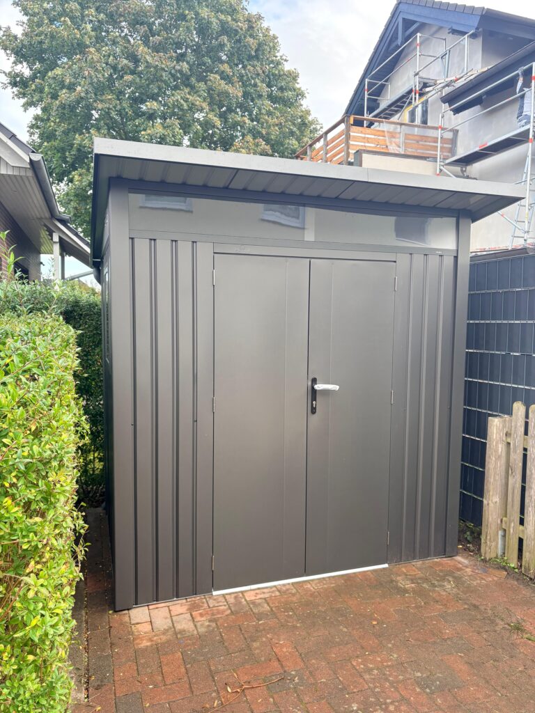 Metall-Gartenhaus mit geschlossener Tür und Dachüberstand